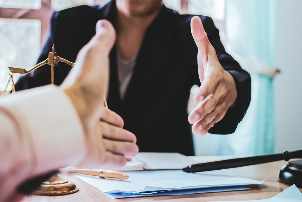 Close-up Shake hands lawyers in office. Counseling and Give an advice between private and government officials to find a fair settlement.